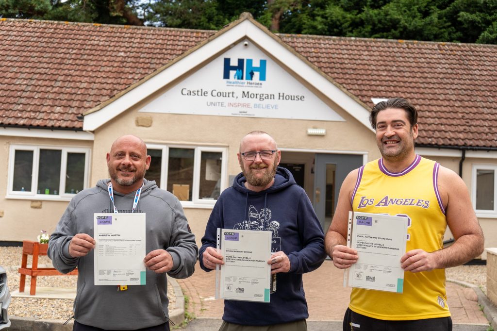 Three veterans holding their certificates outside Castle Court